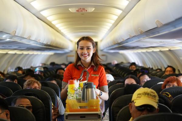 Tiếp viên hàng không nữ phục vụ nước trên máy bay
